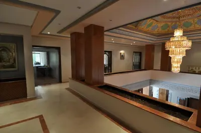 a lobby with a large mirror and a chandelier at Hôtel Wassim in Fès