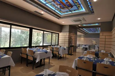 a restaurant with tables and chairs and a skylight at Hôtel Wassim in Fès