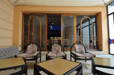 a patio with chairs and tables and a bar at Hôtel Wassim in Fès