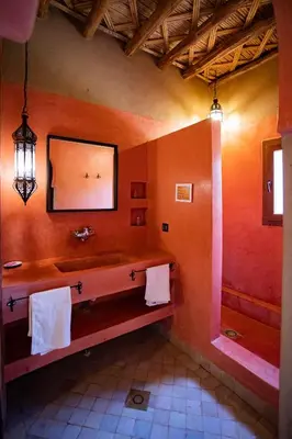 a bathroom with a sink and a mirror and towels at Kanz Erremal in Merzouga