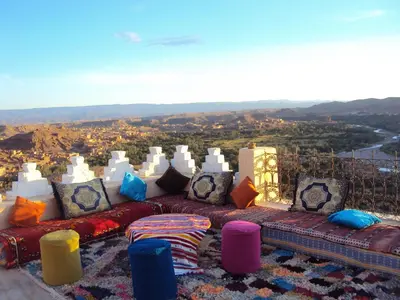 a couch with colorful pillows sitting on top at Dar Timitar in Kalaat MGouna
