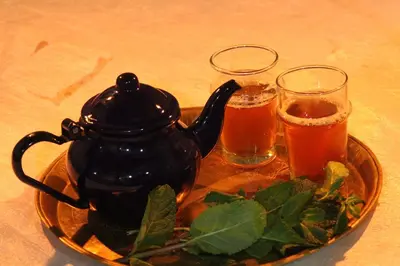 a tea kettle and two glasses of beer on a plate at Dar Timitar in Kalaat MGouna