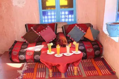 a couch with a table with candles on it at Dar Timitar in Kalaat MGouna