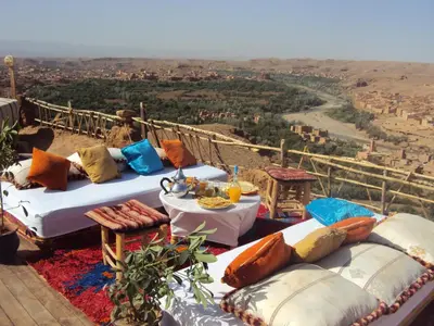 a table with pillows sitting on top of a building at Dar Timitar in Kalaat MGouna