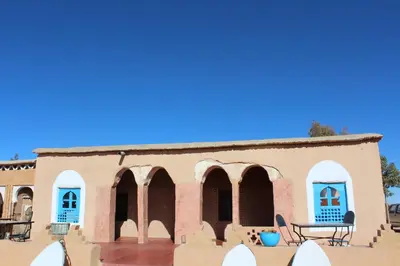 an old building in the desert with blue doors at Dar Timitar in Kalaat MGouna