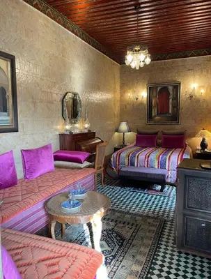 a room with two beds and a couch and a table at Dar Tazi - Medina View in Fès