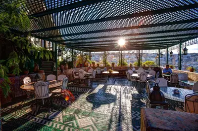 a restaurant with tables and chairs and a view of the city at Dar Tazi - Medina View in Fès