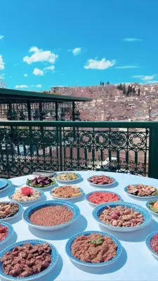 a table with many plates of food on a balcony at Dar Tazi - Medina View in Fès