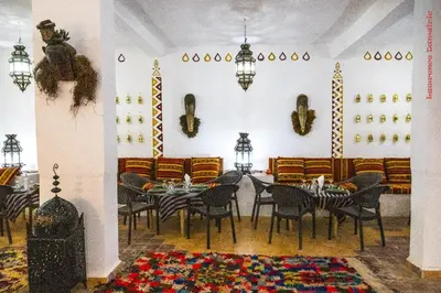 a dining room with tables and chairs in a room at Hotel Riad Sahara Activity in Mhamid