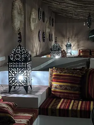 a room with three lamps and a table with pillows at Hotel Riad Sahara Activity in Mhamid
