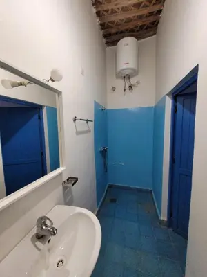 a bathroom with a sink and a blue door at Hotel Riad Sahara Activity in Mhamid