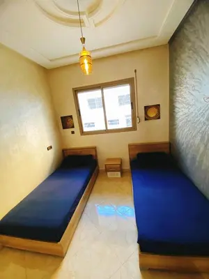 a bedroom with two blue beds in a room at Appartement calme in Fès