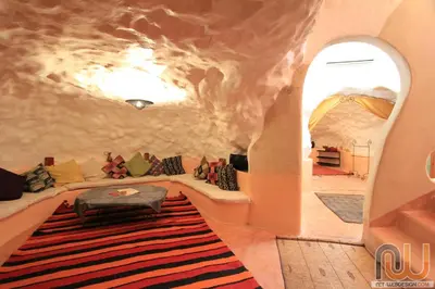 a living room with a faux rock wall at La Perle Du Dades in Boumalne