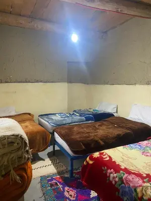a group of beds in a room with a ceiling at Auberge Ouabas in Agoudim