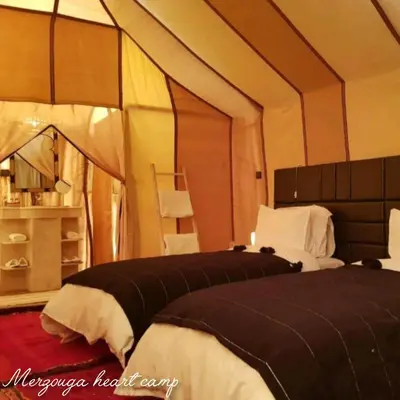 a bedroom with two beds in a tent at Merzouga heart camp in Merzouga