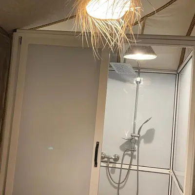 a shower in a bathroom with a glass door at Merzouga heart camp in Merzouga