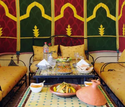 a room with two chairs and a table with food at Riad Fes Baraka & SPA in Fès