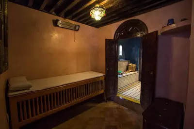 a hallway with a bench in a room with a window at Riad Fes Baraka & SPA in Fès