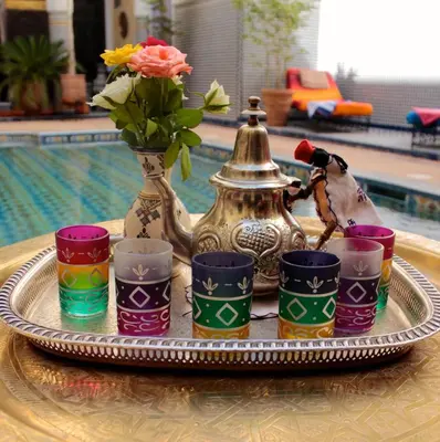 a tray with a tea pot and cups and a vase at Riad Fes Baraka & SPA in Fès