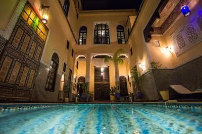 an indoor swimming pool in a building with a swimming pool at Riad Fes Baraka & SPA in Fès