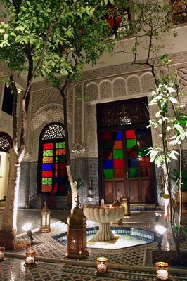 a room with a fountain and stained glass windows at Riad Alya in Fès