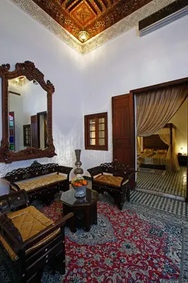 a large living room with a mirror and furniture at Riad Alya in Fès