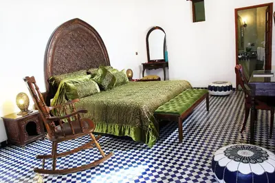 a bedroom with a bed and a chair at Riad Alya in Fès