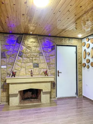 a fireplace in a room with a stone wall at Chalet nina in Azrou