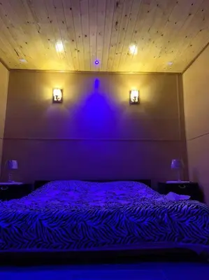 a bedroom with a purple bed with two lights on the wall at Chalet nina in Azrou