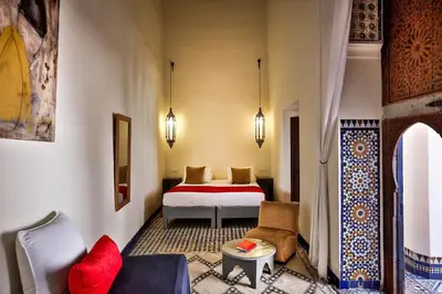 a hotel room with a bed and a couch at Hotel & Spa Dar Bensouda in Fès