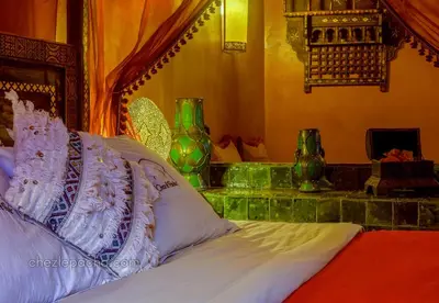 a bedroom with a bed and some green vases at Chez Le Pacha - Authentic Sahara Hotel Mhamid in Mhamid