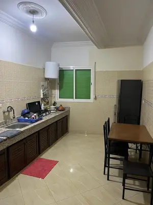 a kitchen with a counter and a table with a laptop at Chez ZAKi in Meknès