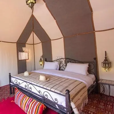 a bedroom with a large bed in a room at Maktub Desert Luxury Camp in Merzouga