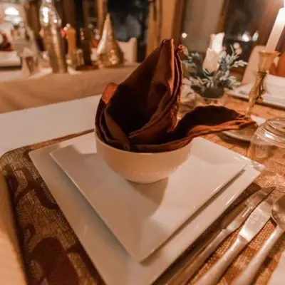 a bowl on a white plate on a table at Maktub Desert Luxury Camp in Merzouga