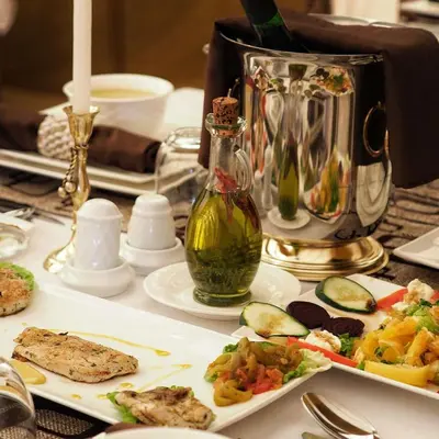 a table with plates of food and a bottle of oil at Maktub Desert Luxury Camp in Merzouga