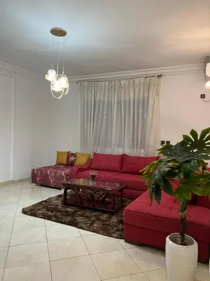 a living room with a red couch and a table at Appartement à beni mellal in Beni Mellal