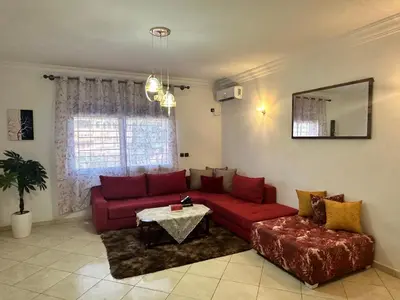 a living room with a red couch and a table at Appartement à beni mellal in Beni Mellal