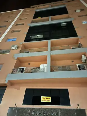 a tall building with a yellow sign on it at Appartement à beni mellal in Beni Mellal