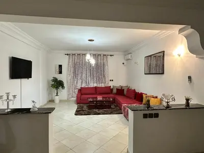 a living room with a red couch and a tv at Appartement à beni mellal in Beni Mellal