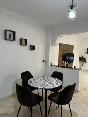 a table and chairs in a room with a kitchen at Appartement à beni mellal in Beni Mellal
