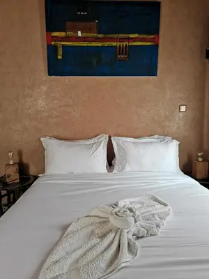 a white bed with a white blanket on it at Maison d'hôte tamatart - Homestay in Kalaat MGouna