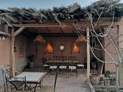 a group of tables and chairs in a patio at Maison d'hôte tamatart - Homestay in Kalaat MGouna