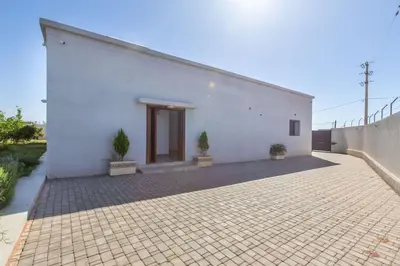 a white building with two potted plants in front of it at Villa Coquelicot, modern style avec jacuzzi, piscine Chauffée in Marrakech