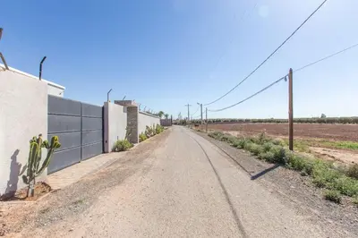 an empty road in the middle of a field at Villa Coquelicot, modern style avec jacuzzi, piscine Chauffée in Marrakech