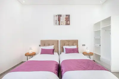 two beds in a room with purple and white at Villa Coquelicot, modern style avec jacuzzi, piscine Chauffée in Marrakech