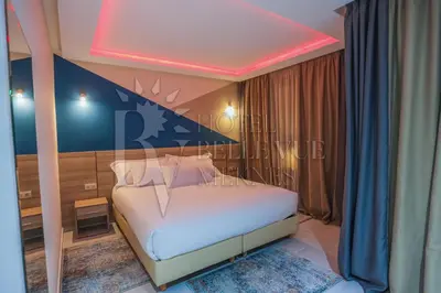 a bedroom with a white bed with a red ceiling at HOTEL BELLE VUE MEKNES in Meknès