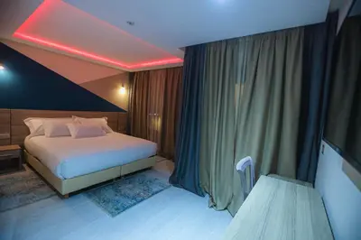 a hotel room with a bed and a red light at HOTEL BELLE VUE MEKNES in Meknès