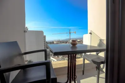 a table and chairs on a balcony with a view of a city at HOTEL BELLE VUE MEKNES in Meknès