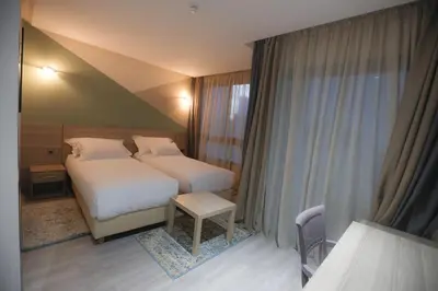 a hotel room with two beds and a window at HOTEL BELLE VUE MEKNES in Meknès