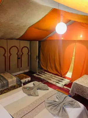 a bedroom with two beds and a tent at Glance over nights at luxury in Merzouga